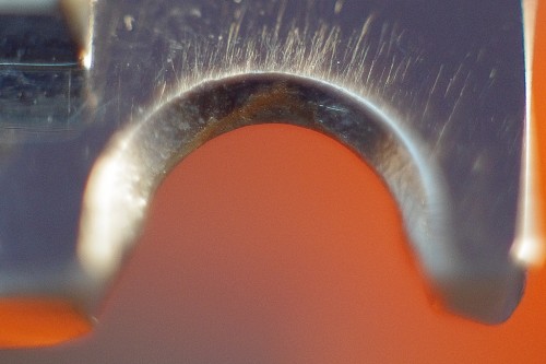 A tremoló élének érintkezési pontja a rögzítőcsavarral, jól látható a kopás